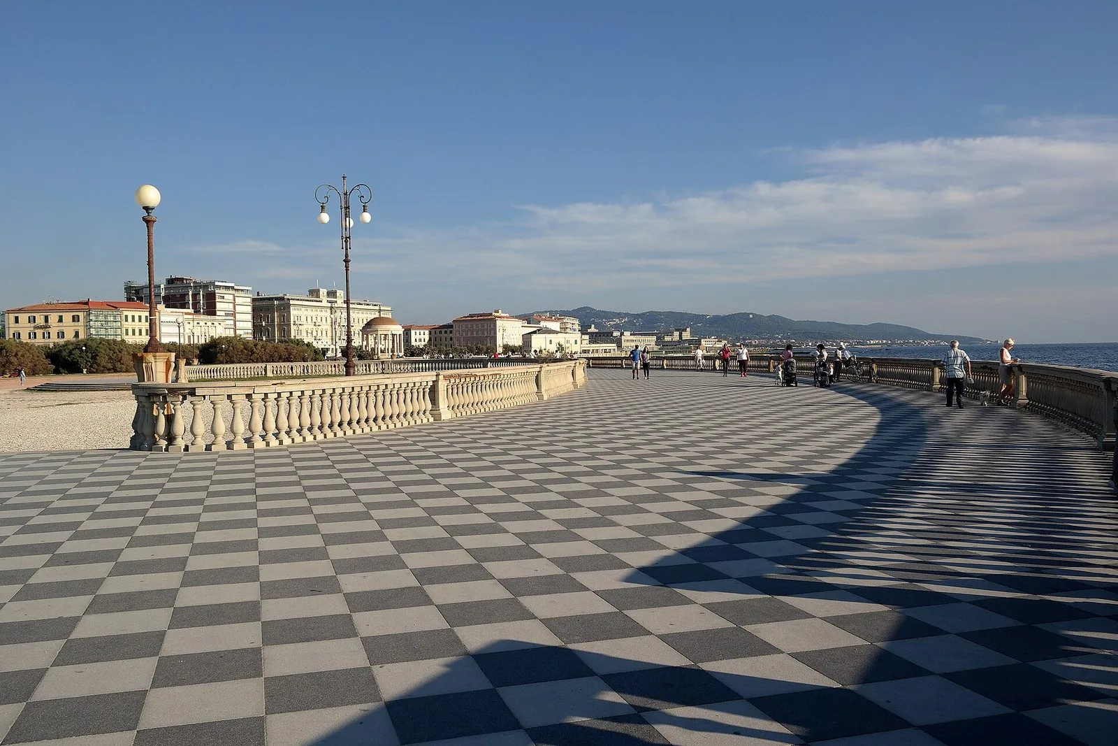 La Terrazza Mascagni in una giornata limpida: la grande pavimentazione a scacchi bianchi e neri, la balaustra chiara e i lampioni, con i palazzi del lungomare, il gazebo a cupola e le colline sullo sfondo