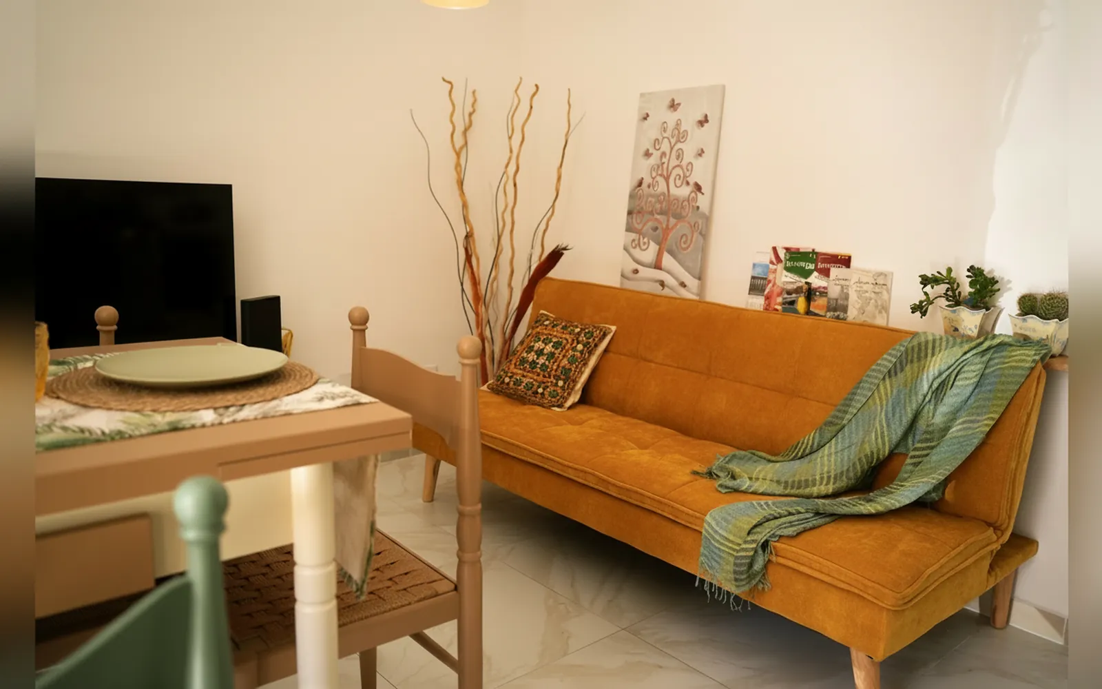 Il divano letto color senape accanto al tavolo della zona giorno